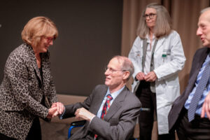 Marty Liggett, executive director of the American Society of Hematology, congratulates J. Evan Sadler, MD, PhD, after presenting him with the society's Exemplary Service Award. Victoria Fraser, MD, head of the Department of Medicine, and longtime colleague David Ginsburg, MD, PhD, of the University of Michigan, look on. Sadler, director of the Division of Hematology, received the award at a recent symposium held in his honor.